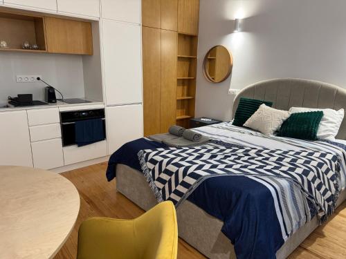 a bedroom with a bed and a table and a kitchen at Porto Suites in Porto