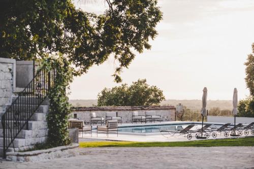a swimming pool with tables and chairs next to a building at San Tomasini Heritage Hotel & Wedding Venue in Višnjan