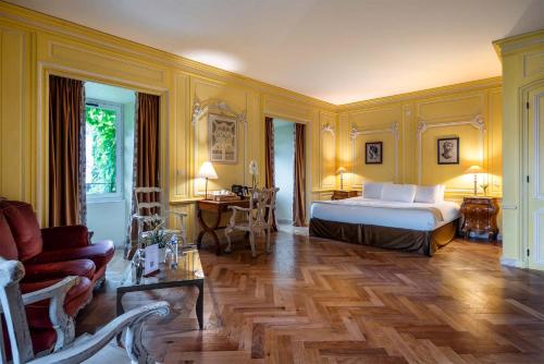 a bedroom with a bed and a couch and a table at Château de Candie in Chambéry