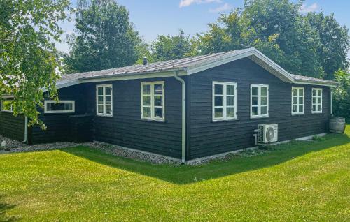 a small blue house with windows and a yard at Pet Friendly Home In Grevinge With Wifi in Grevinge