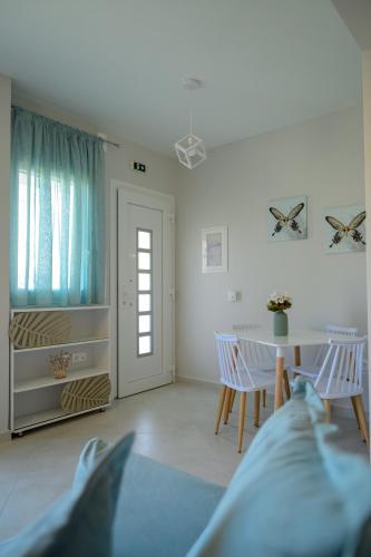 a white living room with a table and chairs at Sotale Suites in Apolpaina