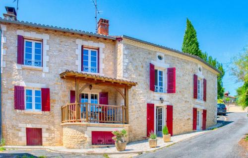 a large stone house with red shutters at Charmante Maison Avec Piscine in Savignac-les-Églises
