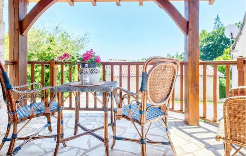 a patio with chairs and a table with a vase of flowers at Charmante Maison Avec Piscine in Savignac-les-Églises