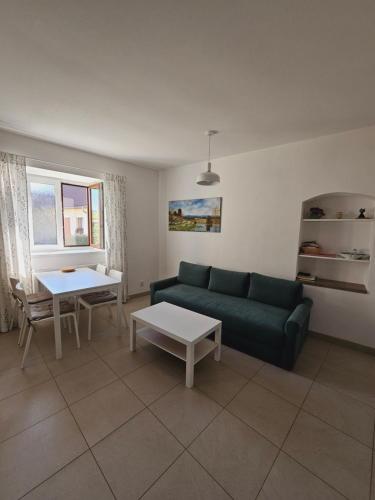 a living room with a green couch and a table at Penzion U strejčků in Veselí nad Lužnicí