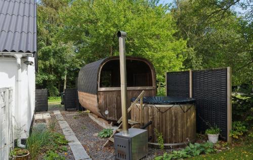 a wooden caravan sitting in a yard next to a fence at Lovely Home In Thyholm With Sauna in Thyholm