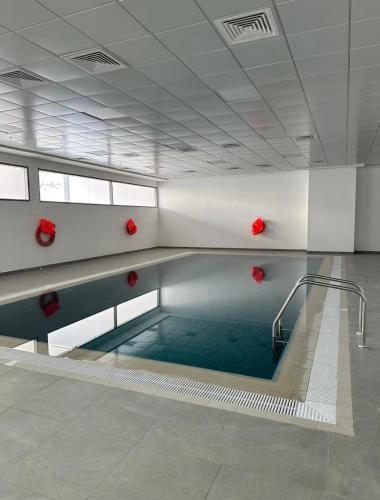 a swimming pool in a building with red balls in it at Appartement 1BR de 2024 avec piscine et salle de sport in Ajman