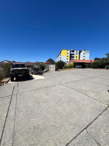 a parking lot with a truck parked in front of a building at Maylands Riverside City Retreat in Perth