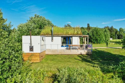 a small house with a grass roof at Kevade talu puhkemaja in Rämsi