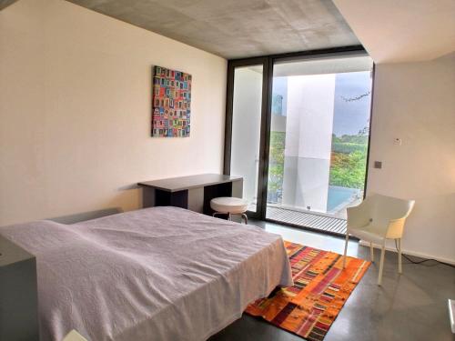 une chambre avec un lit, un bureau et une fenêtre dans l'établissement Villa Contemporaine, GOLF AND SEA, Haut de gamme, Vue LAC, à Anglet