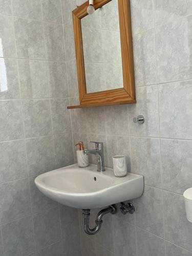 a white sink in a bathroom with a mirror at Proavlio in Moutsoúna