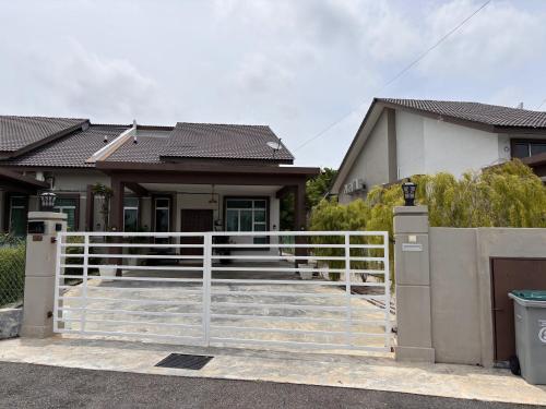 a house with a white fence in front of it at Duyong Damai Homestay by KOWBMAS in Melaka