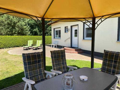 a table and chairs under an umbrella on a patio at Ferienhaus Geers am Klostersee Dargun in Dargun