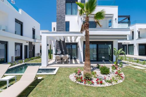 an exterior view of a villa with a palm tree at Olympiada Residential Complex & Villas in Ofrínion