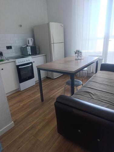 a small kitchen with a table and a refrigerator at Satsiti Блок Н in Astana