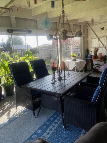 a wooden table with chairs and candles on a patio at Kulla Skola in Veddige