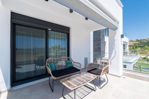 two chairs on a balcony with a view of the ocean at Olympiada Residential Complex & Villas in Ofrínion