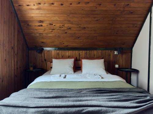 a bedroom with a large bed with a wooden ceiling at Brvnara Majstorović in Divčibare