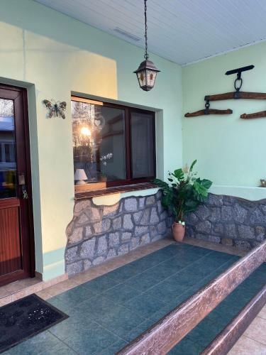 a porch with a stone wall and a window at Bungalow am Hellbach XL im Ostseeland in Neubukow
