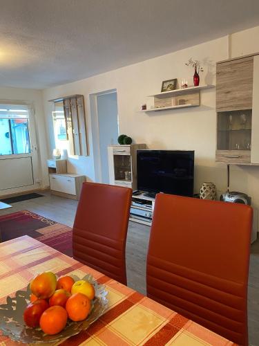 a kitchen with a table with a plate of fruit on it at Bungalow am Hellbach XL im Ostseeland in Neubukow