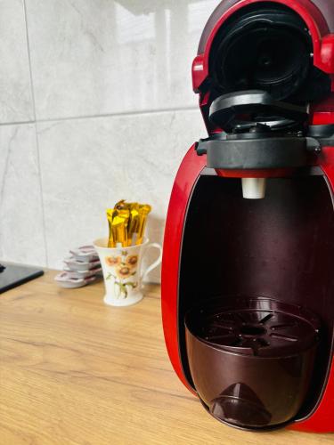 a red mixer sitting on a table with a cup of food at Apartament Mazurski Azyl in Szczytno