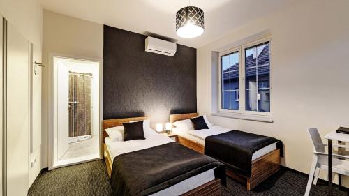 a hotel room with two beds and a window at Penzion Bird's Nest in Brno