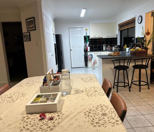 a kitchen with a table with a counter top at Orchid House Shared in Stanthorpe