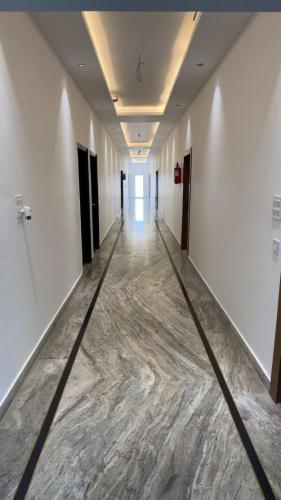 an empty hallway with a marble floor in a building at The Aana Hotel Sohna -Gurgaon Road in Gurgaon