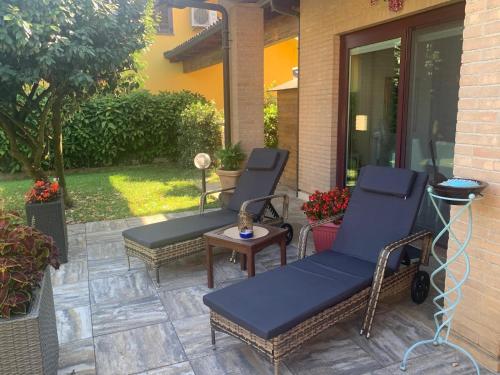 Dos sillas y una mesa en un patio. en Villa Rosa, en Givoletto