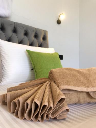 a pile of towels sitting on top of a bed at Tunnel Top Inn Ella in Ella
