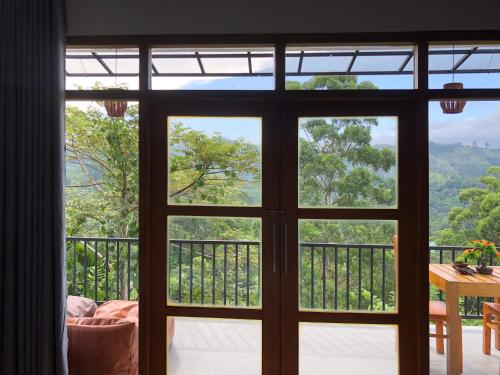 an open glass door with a view of the mountains at Tunnel Top Inn Ella in Ella