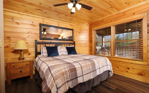 Un dormitorio con una cama en una cabaña de troncos en The Song Bird, en Gatlinburg