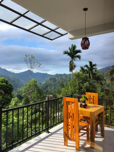 a wooden table and chairs on a balcony with a view at Tunnel Top Inn Ella in Ella