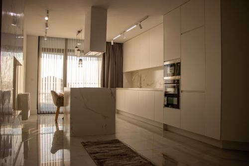 a kitchen with white cabinets and a counter top at White Hill Hotel, SPA & Conferences in Durrës