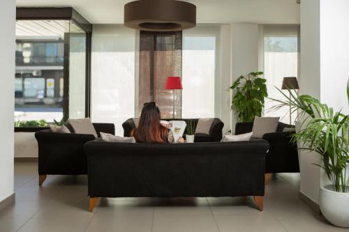 a woman sitting at a table in a living room at Toscana Ambassador in Poggibonsi