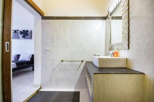 un baño con lavabo y espejo en Villa Langit Ocean View Jimbaran, en Jimbaran