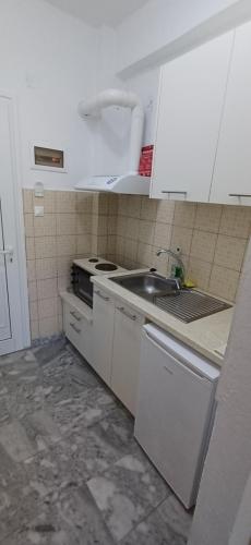 a white kitchen with a sink and a stove at Villa Kavourakia in Kolios