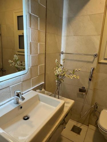 a bathroom with a sink and a toilet and a mirror at Hotel apartments Ninety Avenue New Cairo in Cairo