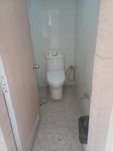 a bathroom with a white toilet in a room at Indo Hokke Hotel in Rājgīr