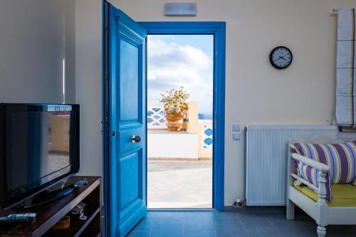 a room with a blue door and a television at Olympos Archipelagos in Olympos