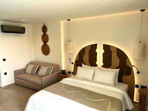 a bedroom with a large bed and a chair at Cabana Blu Hotel & Suites in Kardamaina