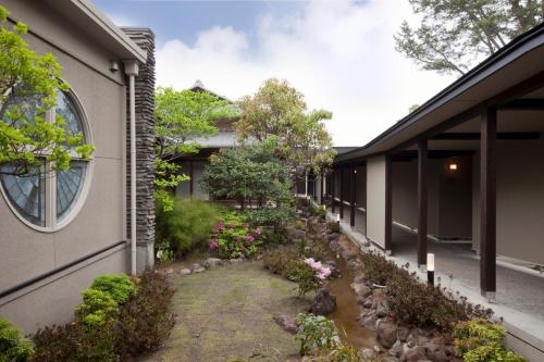 a courtyard of a building with flowers and plants at AMANE resort GAHAMA in Beppu