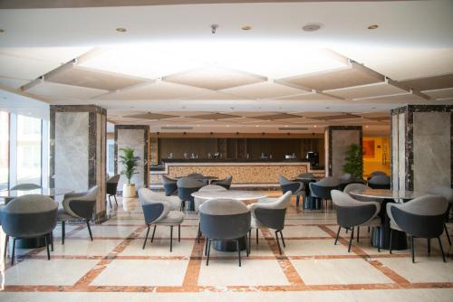 a restaurant with tables and chairs in a lobby at Rewaya Majestic Resort in Hurghada