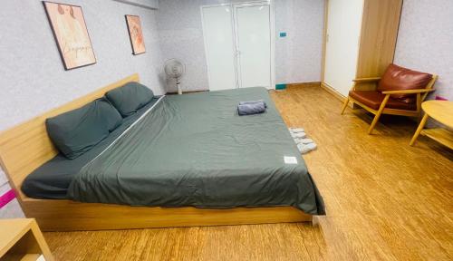 a bedroom with a large bed and a chair at Laca Home in Hanoi