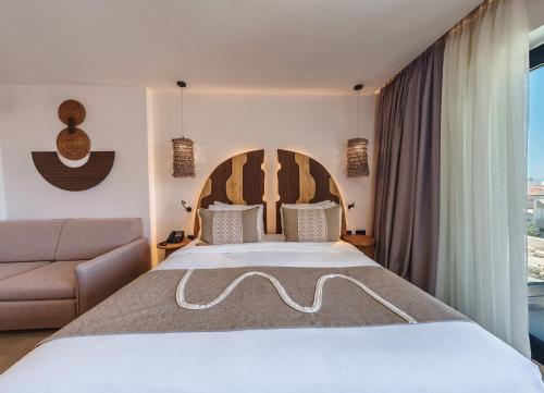 a bedroom with a large bed and a couch at Cabana Blu Hotel & Suites in Kardamaina