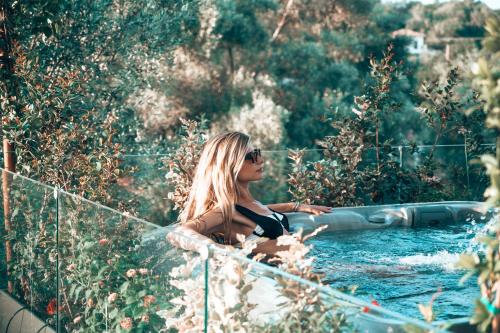 a woman sitting in a bathtub in a garden at September15 Suites- Meganisi in Meganisi