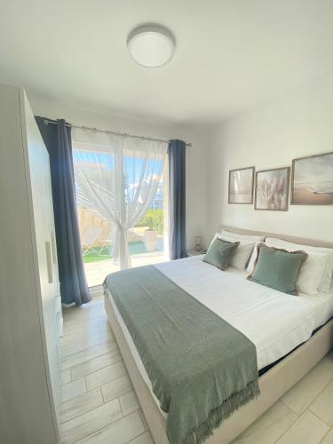 a bedroom with a large bed and a large window at Acquamarina in Pachino