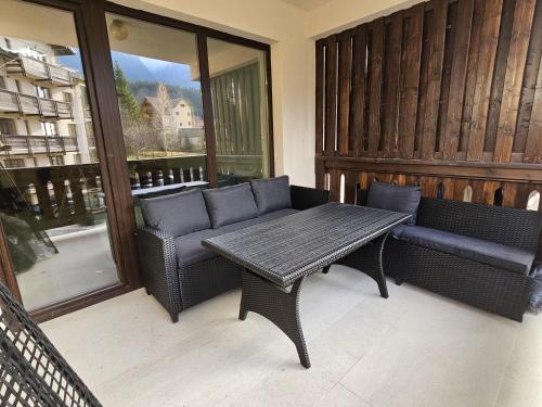 a screened in porch with a table and chairs at Snow Apartament in Buşteni