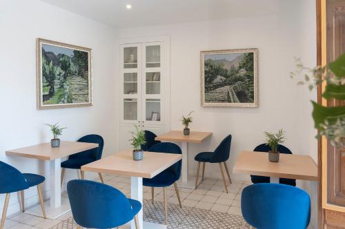 a room with four tables and blue chairs at Petit Biniaraix in Sóller
