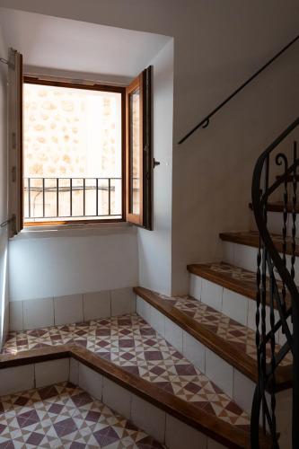 an empty room with stairs and a window at Petit Biniaraix in Sóller