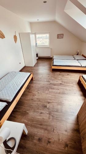 two beds in a room with wooden floors at Apartmán Bessy in Borovany